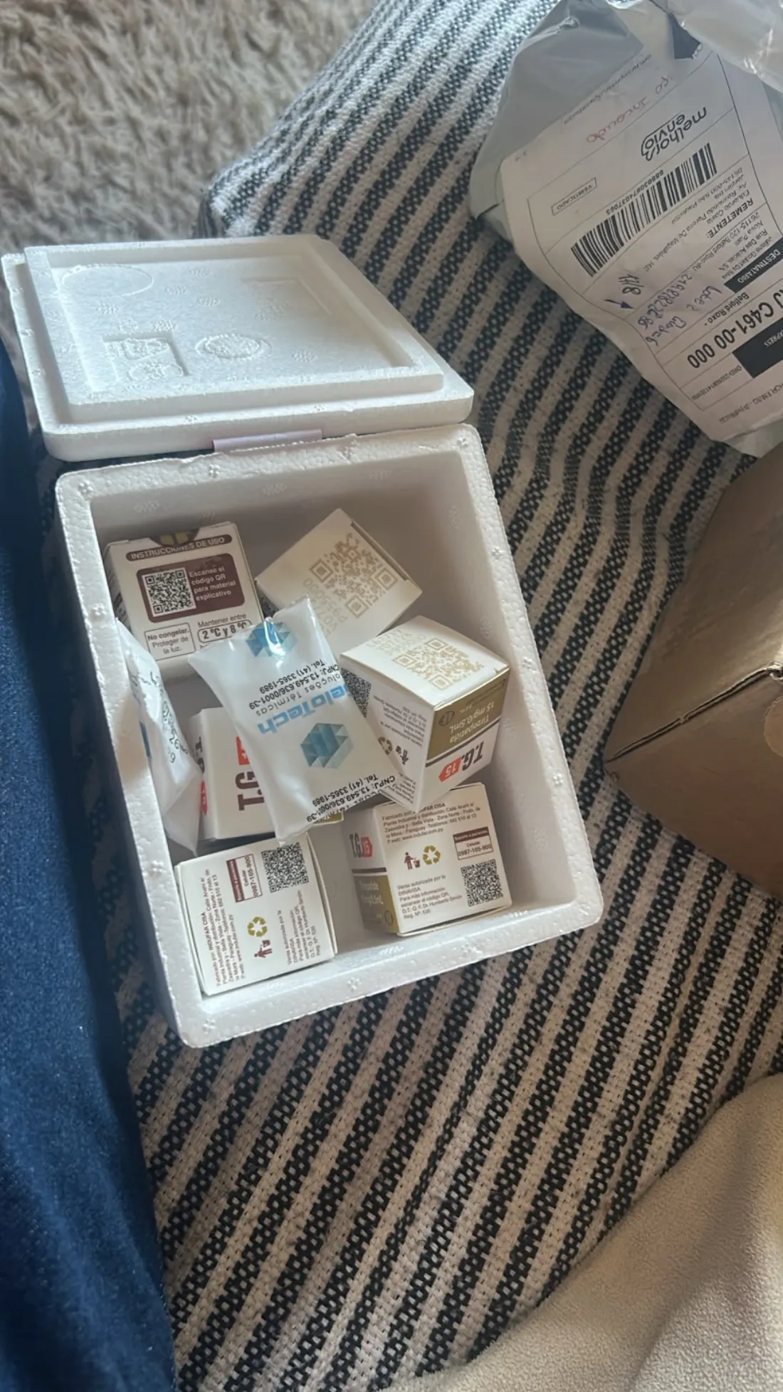 Caixa térmica aberta ao lado do pacote de envio recebido em casa